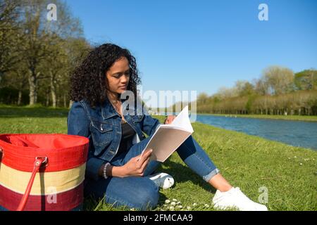 metis donna che legge in natura Foto Stock