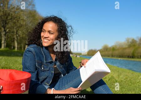 metis donna che legge in natura Foto Stock