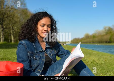 metis donna che legge in natura Foto Stock