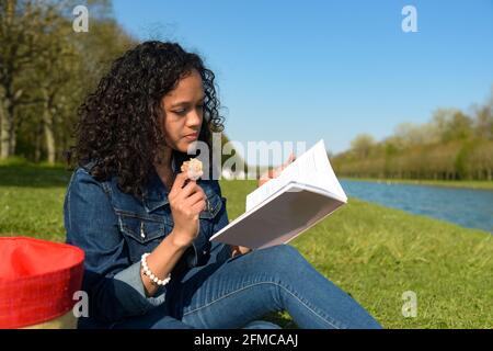 metis donna che legge in natura Foto Stock