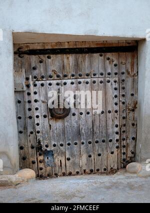 Una vecchia e delapidated chiodo-borchiata porta posteriore nel villaggio di Torrebaja in Valancia, Spagna Foto Stock