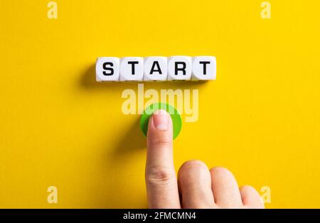 La parola inizia sui cubi con una mano maschio che preme il pulsante di avvio. Per fare un nuovo inizio nella vita, nel commercio, nell'istruzione o nel concetto di carriera. Foto Stock