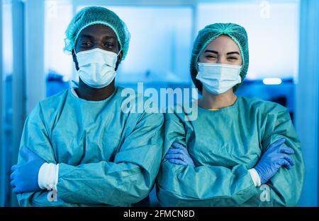 Medici multirazziali che indossano dispositivi di protezione personale che combattono contro il virus della corona Focolaio - concetto di assistenza sanitaria e lavoratori medici Foto Stock