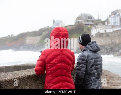 Cornovaglia, Regno Unito. 8 maggio 2021. Nonostante gli alti venti, due persone si levano in piedi e guardano il mare estremamente tempestoso a Porthleven, Cornovaglia. La temperatura era di 12C, la previsione è per pioggia e forti venti nei prossimi giorni. Credit: Keith Larby/Alamy Live News Foto Stock