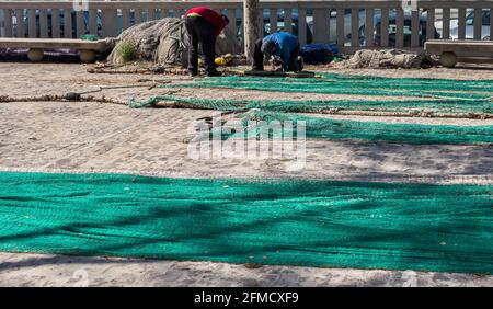 Palma de Mallorca, Spagna 03-24-2021: Pescatore che ripara reti da pesca al molo di Palma de Mallorca Foto Stock