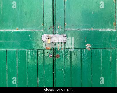 Porte in legno verniciato verde con chiusura di sicurezza, fiocco e lucchetto in ottone Foto Stock