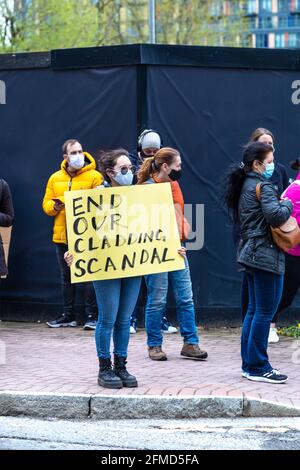 8 maggio 2021, Londra, Regno Unito - i manifestanti si sono riuniti a South Quay, Canary Wharf, per protestare contro i rivestimenti non sicuri e infiammabili degli edifici il giorno dopo il vicino incendio di New Providence Wharf, una donna che teneva un cartello con la scritta "End our Clading scandalo" Foto Stock