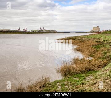 Alta marea ad Avonmouth sul fiume Avon vicino a Bristol UK con gru dei Portbury Docks in lontananza Foto Stock