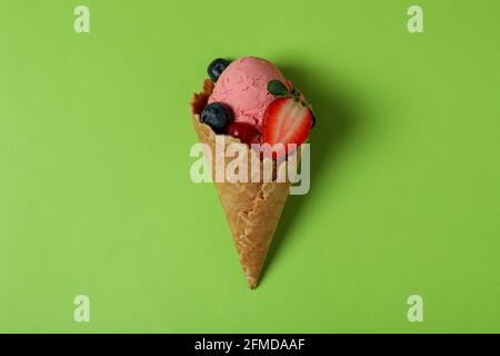 Cono di gelato alla frutta su sfondo verde Foto Stock