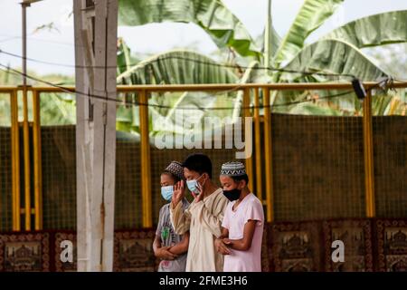 Marikina città, Filippine. 8 maggio 2021. I musulmani filippini che indossano maschere protettive come precauzione contro lo scoppio del coronavirus si riuniscono mentre assistono ad una preghiera di mezzogiorno in osservanza di Ramadan all'interno di una comunità musulmana. Foto Stock