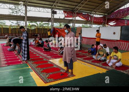 Marikina città, Filippine. 8 maggio 2021. I musulmani filippini che indossano maschere protettive come precauzione contro lo scoppio del coronavirus si riuniscono mentre assistono ad una preghiera di mezzogiorno in osservanza di Ramadan all'interno di una comunità musulmana. Foto Stock