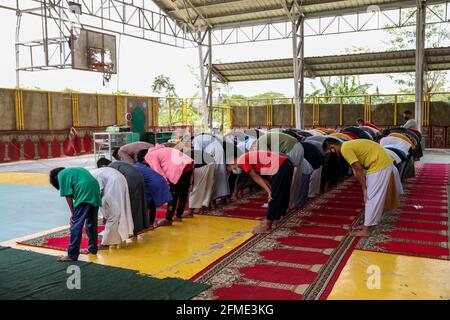 Marikina città, Filippine. 8 maggio 2021. I musulmani filippini che indossano maschere protettive come precauzione contro lo scoppio del coronavirus si riuniscono mentre assistono ad una preghiera di mezzogiorno in osservanza di Ramadan all'interno di una comunità musulmana. Foto Stock