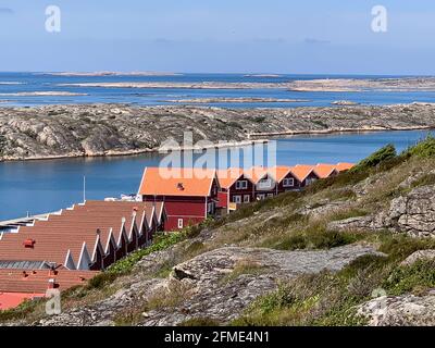 Smogen, Svezia - 1 giugno 2017: Un gruppo di tipiche case rosse svedesi sulla spiaggia di un fiordo di Smogen Foto Stock