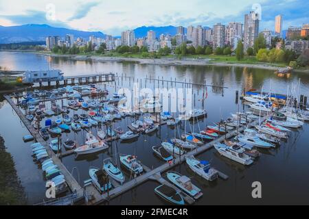 Vista serale estiva sulle barche del porto civico di Burrard e Sunset Beach attraverso l'insenatura nella English Bay con skyline cittadino del centro di Vancouver, Foto Stock