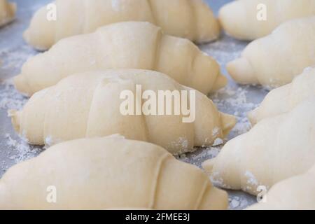croissant preparati per essere cotti sulla teglia da forno Foto Stock