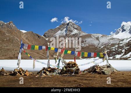 Bandiere di preghiera sul lago glaciale nelle montagne dell'Himalaya, circuito di Annapurna, Nepal. Foto Stock
