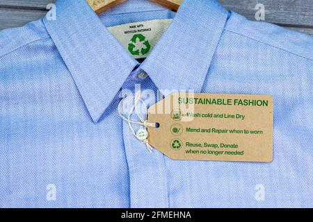 Realizzata con materiali riciclati, camicia con etichetta per la cura della moda sostenibile, fashion wash cold, line dry, mend and repair, riutilizzo, scambiare o donare con icone Foto Stock