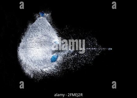 esplosione di un pallone riempito d'acqua su uno sfondo nero, sparato attraverso un proiettile, fotografia ad alta velocità, esplosione rinfrescante, fucile congelato colpo, ho Foto Stock