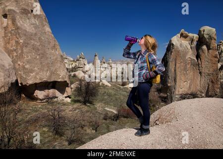 Donna escursionista che prende una bevanda in Cappadocia, Turchia Foto Stock