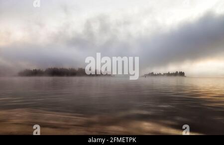 Due isole sul lago Jindabyne di Snowy River - luce del sole al sole in nebby tempo nuvoloso. Foto Stock