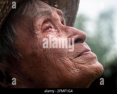 Primo piano di un anziano asiatico molto felice in piedi in un giardino e di fronte al cielo. Gli agricoltori sono felici della pioggia a seconda della stagione. Foto Stock