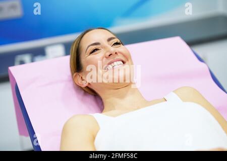 Donna di mezza età sdraiata sulla barella in una clinica estetica. Foto Stock