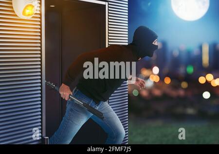 Ladro con balaclava corre via dall'appartamento perché il l'allarme è stato attivato Foto Stock