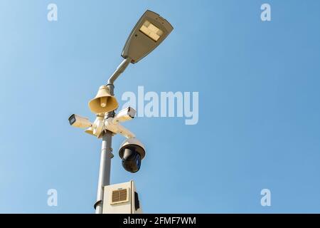 Un gruppo di telecamere di sicurezza su un lampione, in un parco pubblico sullo sfondo del cielo, con spazio di copia Foto Stock