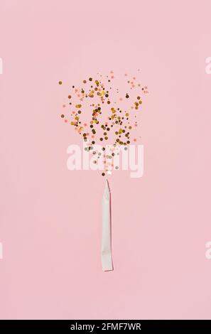 Esplosione di scintille da sigaretta di carta arrotolata hahd, su sfondo rosa pastello. Posa piatta. Foto Stock