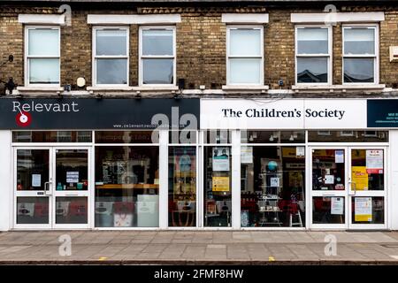 Una vista esterna del pertinente Record cafe e negozio di dischi accanto al negozio di beneficenza della Children's Society. Mill Road, Cambridge, Regno Unito Foto Stock