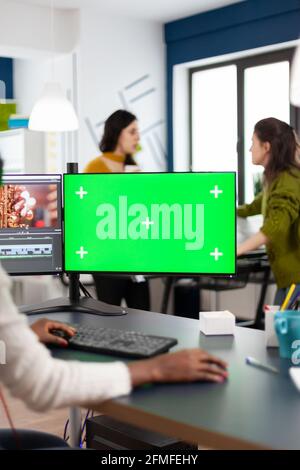 Videografo nero che si esibisce al pc con chiave Chroma, simulato schermo isolato editing video filmati. Editor africano che elabora il montaggio di film su schermo verde lavorando in azienda multimediale digitale Foto Stock