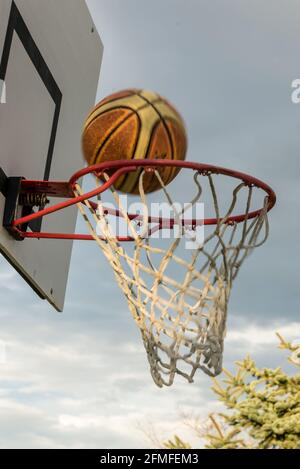 La pallacanestro attraversando hoop Foto Stock