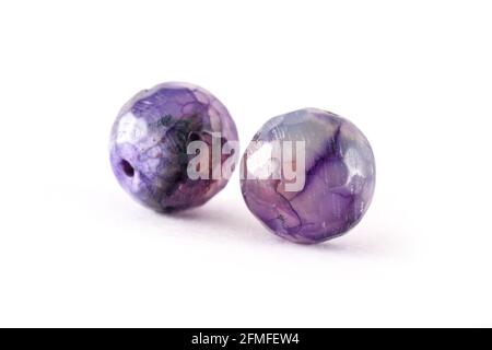 Perline di agata viola modellate isolate su perline bianche, tonde di Agata, pietre semi preziose. Perle minerali naturali. Perline fatte di pietre naturali per creare j Foto Stock