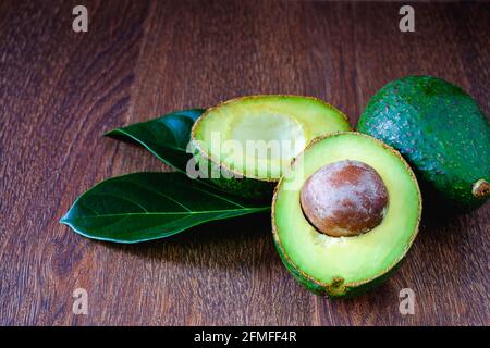 Avocado frutta e foglie su tavole di legno. Foto Stock