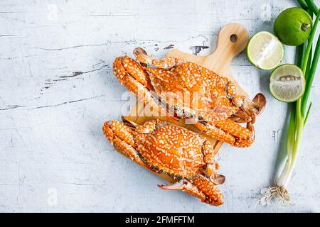 Pesce granchio cotto a vapore su sfondo di legno bianco Foto Stock