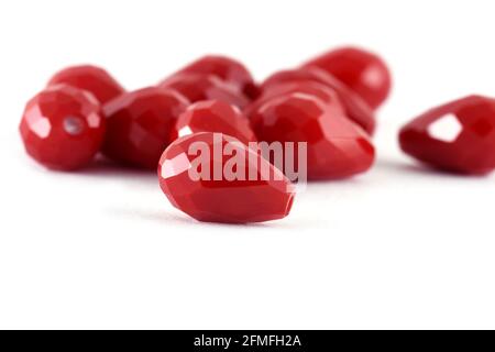 Forma goccia Beads rosso sparso su sfondo bianco. Sfondo o struttura di beads.Close up, usato per rifinire abiti di moda. Fare collana di perle o stri Foto Stock