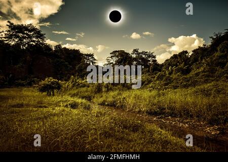 Totale eclissi solare che brilla su cielo sopra deserto in foresta. Incredibile fenomeno scientifico naturale quando la luna passa tra terra del pianeta e sole. Se Foto Stock