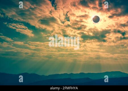 Incredibile fenomeno scientifico naturale. La Luna che copre il sole. Eclissi solare totale con effetto anello diamante che illumina sul cielo sopra la catena montuosa. Se Foto Stock