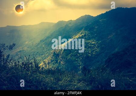 Incredibile fenomeno scientifico naturale. La Luna che copre il sole. Eclissi solare totale con effetto anello diamante che illumina sul cielo sopra la catena montuosa. Se Foto Stock