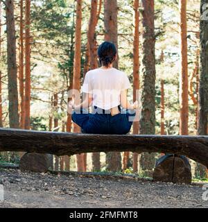 Giovane donna che fa yoga in una foresta. Rapporto quadrato. Foto Stock