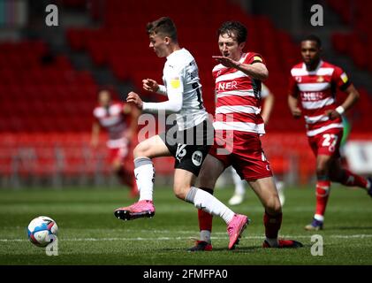 Tom Anderson di Doncaster Rovers e Harrison Burrows di Peterborough United (a sinistra) combattono per la palla durante la partita di Sky Bet League One al Keepmoat Stadium di Doncaster. Data immagine: Domenica 9 maggio 2021. Foto Stock