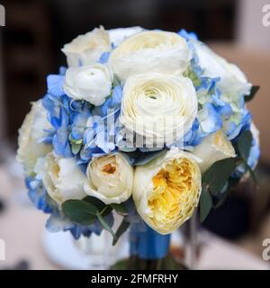 Bouquet di nozze composto da idrangea blu, rose bianco-gialle, rose cremose di pony e ranunculus Foto Stock