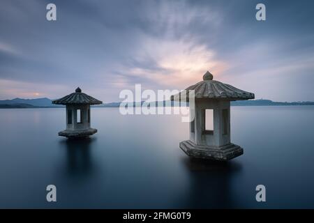 Vista notturna dello splendido paesaggio del Lago Ovest di Hangzhou, con due lanterne in pietra nel lago Foto Stock