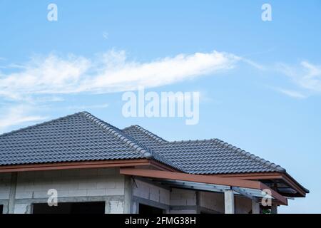 Nuovo tetto di tegole di casa con tetto di tegole spagnolo a costruzione di casa incompiuta, struttura del tetto Foto Stock