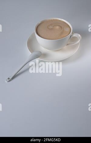 Caffè americano con latte in una tazza bianca e piatto sul tavolo. Caffè del mattino Foto Stock