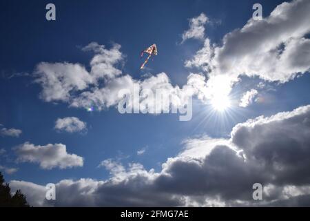 Un aquilone che vola in alto nel cielo blu. Foto Stock