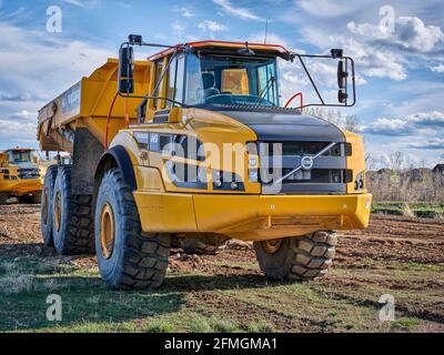 Fort Collins, CO, USA - 28 aprile 2021: Potenti trasportatori di scarico articolati Volvo A45G su un cantiere. Foto Stock
