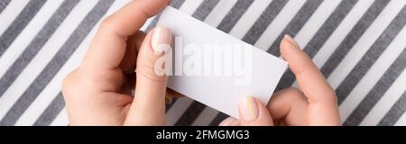 Mani femminili curate che tengono una carta vuota Foto Stock