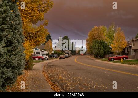 Fort Collins, CO, Stati Uniti d'America - 22 ottobre 2020: Una vista di mezzogiorno di una strada residenziale sotto il plume pesante di fumo dal fuoco selvatico della foresta di montagna - Leve malsano Foto Stock