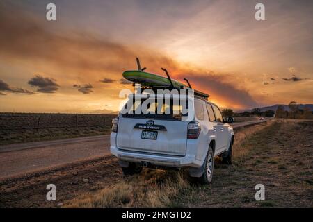 Fort Collins, CO, USA - 15 ottobre 2020: Toyota 4runner SUV con un paddleboard su portapacchi contro il fumo di fuoco selvaggio pennacchio su Rocky Mountains in NOR Foto Stock